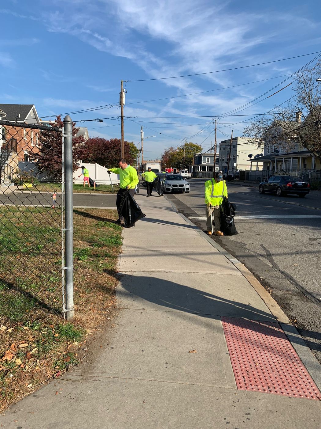 Team members in safety vests cleaning up a Norwalk street