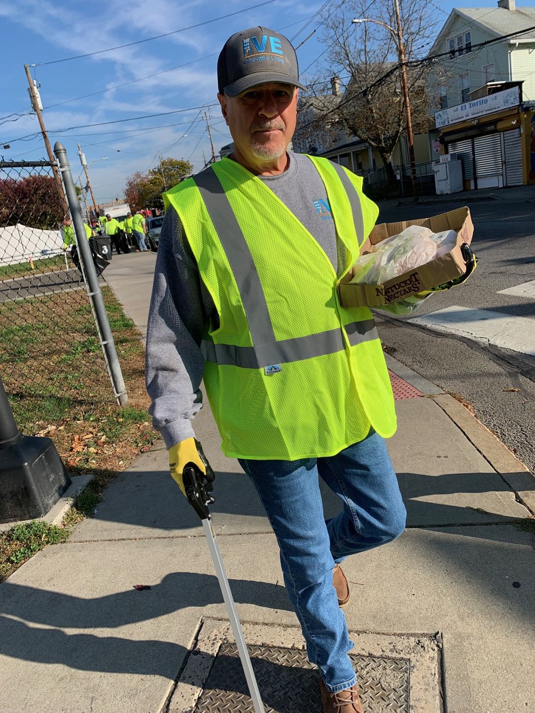 A maintenance team member in a safety vest during a street cleanup